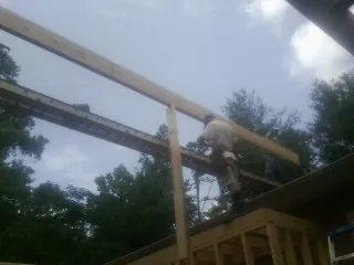 Carpenter setting a ridge beam over a new addition frame — Ice Dam Removal by Roofing Brothers in Corte Madera