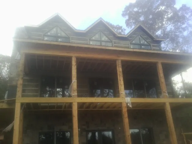 Dormers and porch framing on a large log home under construction — Roof Coating work by our crew in Corte Madera