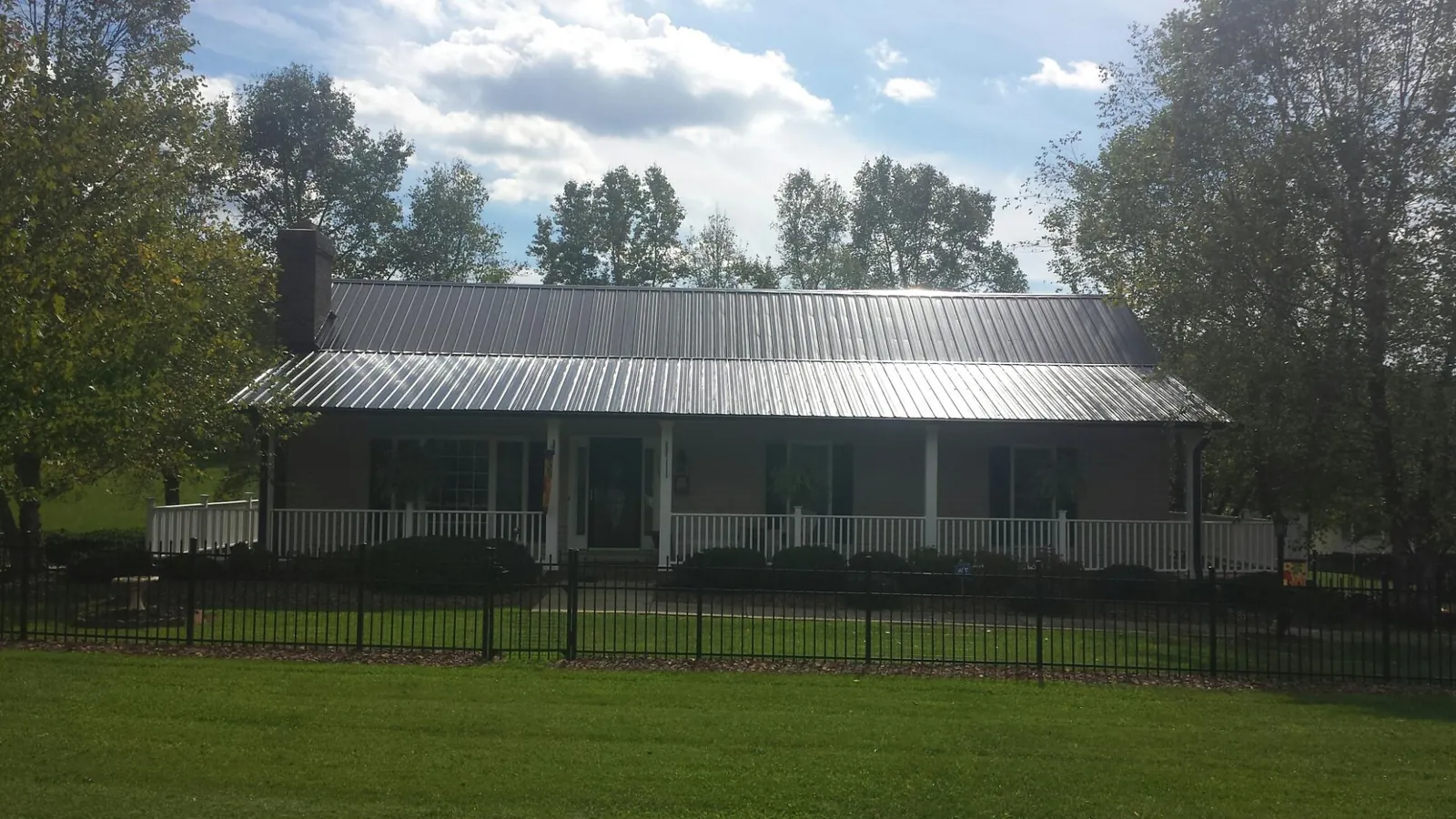 Gray metal roof on a brick ranch with a full width front porch — Gutter Guard Installation work by our crew in Corte Madera
